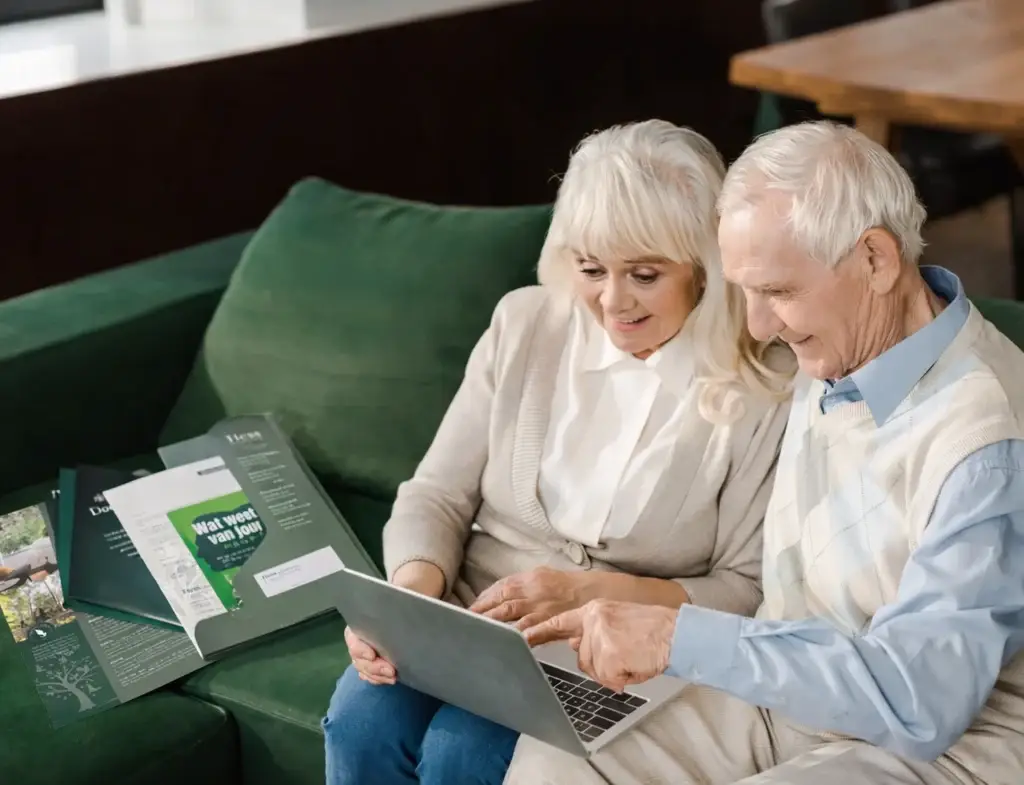 Echtpaar bekijkt thuis informatie en recensies over uitvaartzorg op een laptop