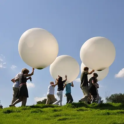 Mensen laten witte ballonnen op als symbolisch afscheid